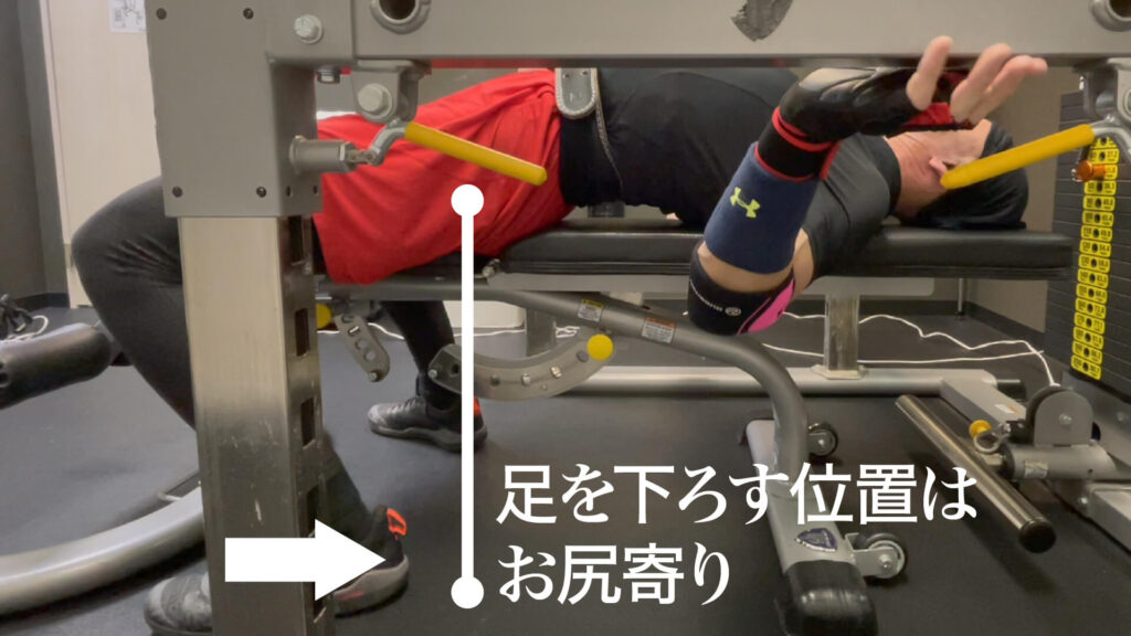 長崎県南島原市最大級の健康体操・ダイエット教室ZUTTOWAKAI　（ずっとわかい）のトレーナー太田祥平がベンチプレス初心者に手本を見せているときの写真。ベンチプレス時に足を下ろす位置はお尻寄りの床になっていることがわかります