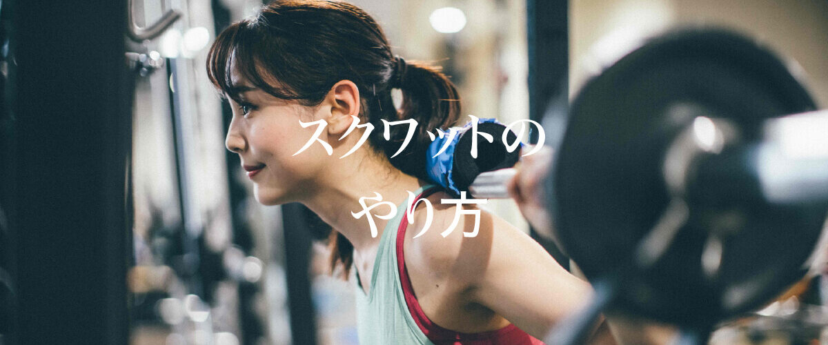 バーベルを担いでスクワットを行う女性。ジムのラック前で真剣な表情を見せながら、正しい姿勢でトレーニングに取り組んでいる。画像中央に「スクワットのやり方」という文字入り。