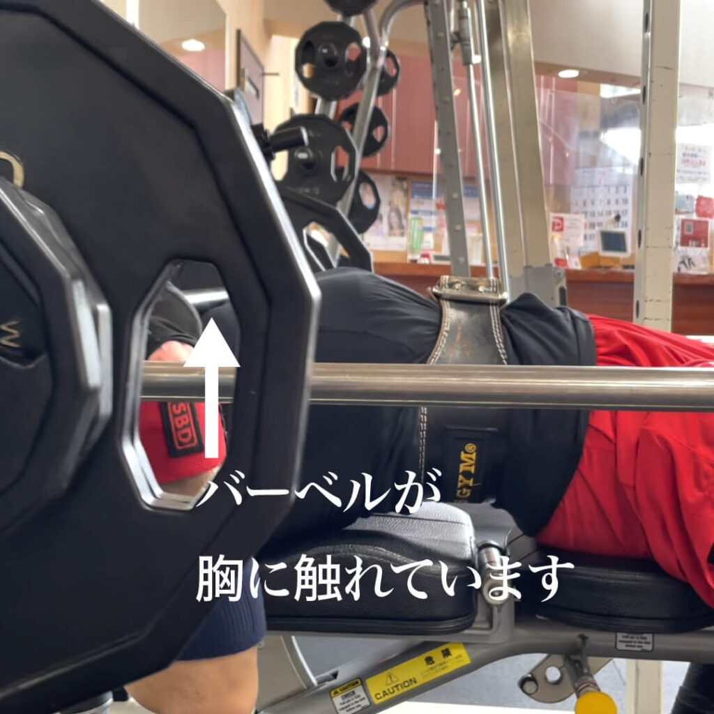 長崎県南島原市最大級のダイエットクラブZUTTOWAKAIエグゼクティブトレーナー太田祥平のベンチプレス初心者レッスン時の写真。ベンチプレスでバーベルを下げた時バーベルが胸へ触れています
